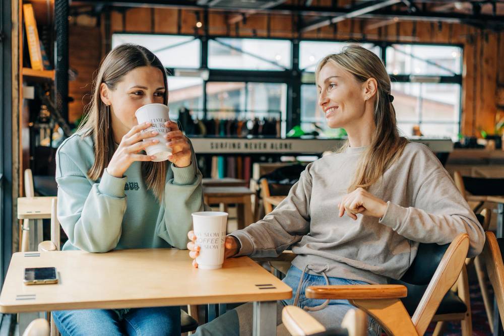 Deux femmes discutent et boivent du café dans un café.